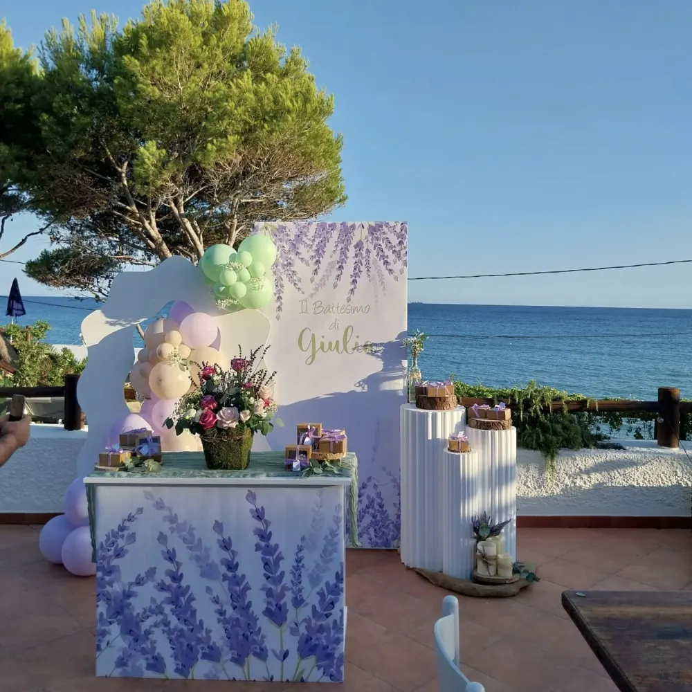 Allestimento battesimo color lavanda sulla terrazza vista mare