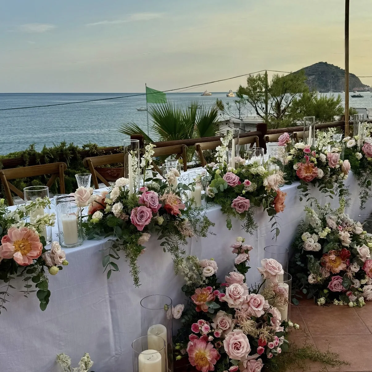 Tavolo sposi con fiori rosa e vista mare